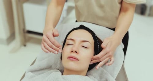 Woman Receiving Facial Massage in a Bright Spa