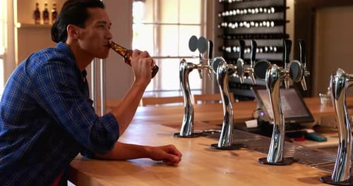 Man having beer at counter in bar 4k