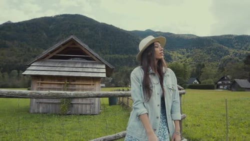 Woman Enjoys Scenic Mountain Views on Rural Farmland