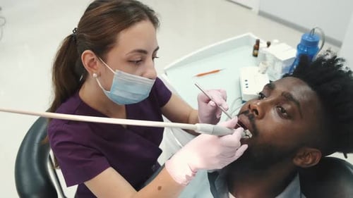 Dentist Examining a Patient's Teeth in the Dentist Office