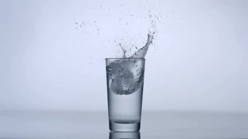 Ice Cubes Splashing into a Glass of Water