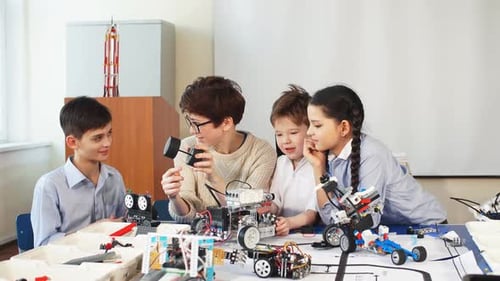 Kids Building Robots with Teacher in Classroom