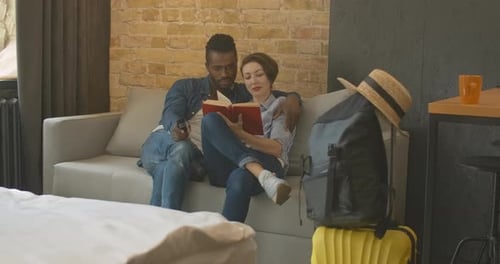 Couple Reading Together in Apartment