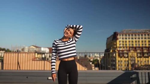Young Woman Stretching on Urban Rooftop