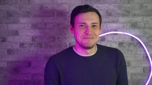Young Adult Smiling in Front of a Neon Light
