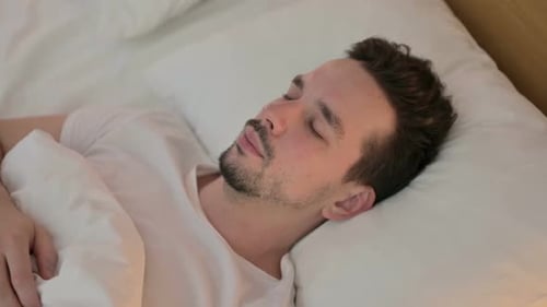 Young Adult Man Sleeping Peacefully in Bed