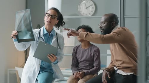 Doctor Explains X-Ray to Child and Father
