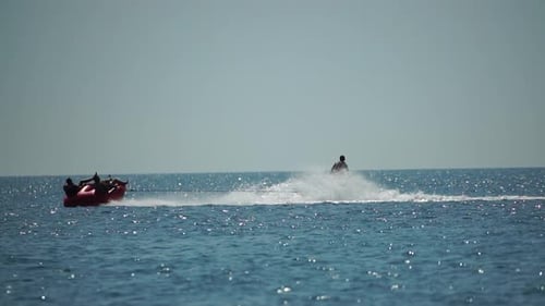 Jet Ski Pulling Raft of People Across Ocean