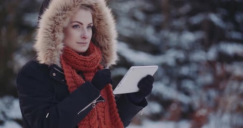 Woman Using Tablet Device in Snowy Winter Landscape