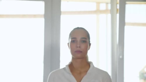 Une sportive joyeuse marche et sourit dans une chambre spacieuse et lumineuse