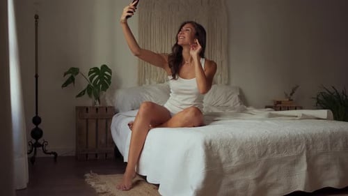 Woman Takes Selfies on Bed in Minimal Bedroom