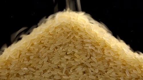Pouring rice on a black background.