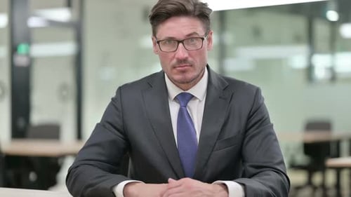 Man in Suit Raises Finger to Emphasize Point