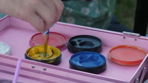 Close Up of Brush Dipping into Yellow Paint