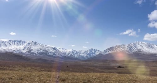 Timelapse of Sun Movement on Crystal Clear Sky with Clouds Over Snow Mountain Top