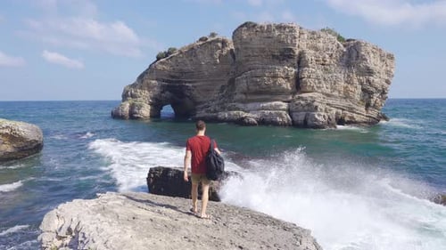 The man watching the sea on the edge of the cliff.