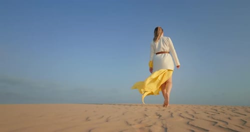 Low Angle of Sexy Girl Walking Barefoot on Sand in Desert