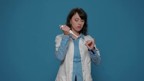 Woman Scientist Using Pipette in Lab on Blue Background