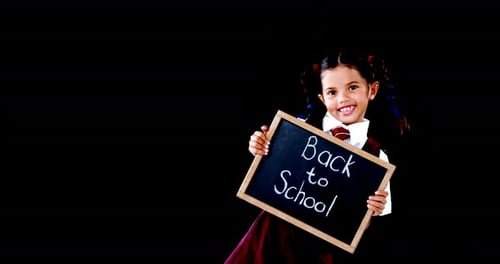 Schoolgirl holding slate with text against black background