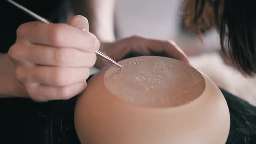 Artist Hand-Crafting a Ceramic Bowl with Etching