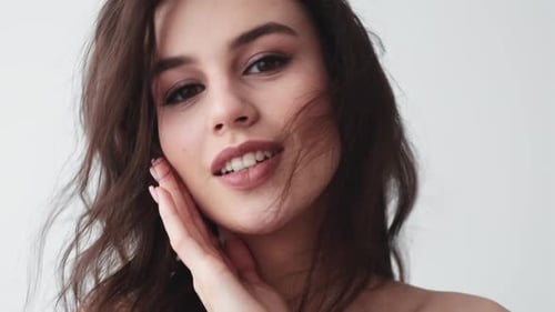 Smiling Woman with Wavy Hair Posing Indoors