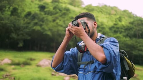 Man Photographing Lush Green Nature with Camera