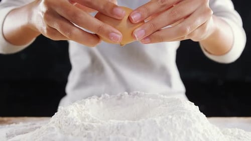 Cracking Egg into Flour Baking Preparation