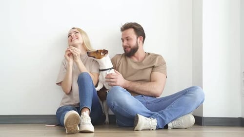 Couple Sitting with Jack Russell Terrier in Home
