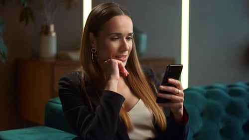 Woman Using Phone on Sofa Indoors