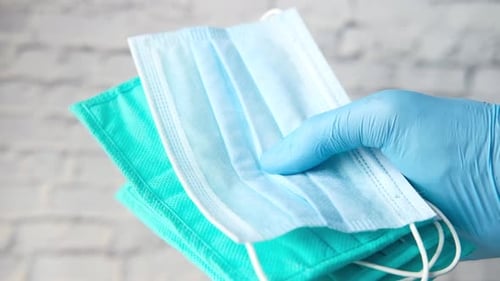 Doctor Hand in Medical Glove Holding Protective Surgical Face Mask, Close Up