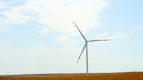 Wind Turbine Turns in Golden Field