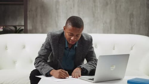 Young Man Working at Home on Laptop