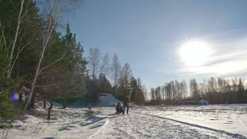 Pais correndo atrás do menino no trenó