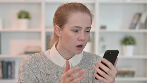 Shocked Woman Looking at Cell Phone