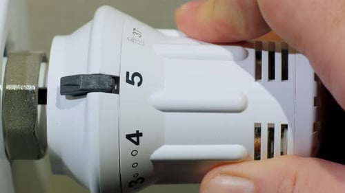 Hand Adjusts Radiator Dial Temperature Close Up
