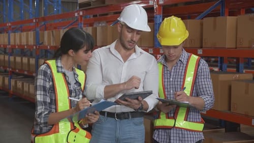 Warehouse Workers Discuss Inventory with Tablet and Clipboard