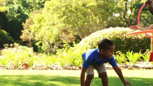 Children Playing with Hula Hoops in Park on Summer Day