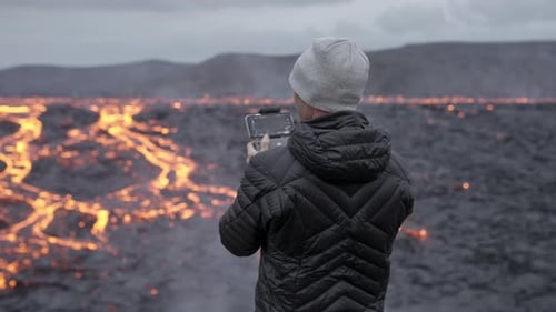 Photographer Controlling Drone And Looking Out Over Lava Field