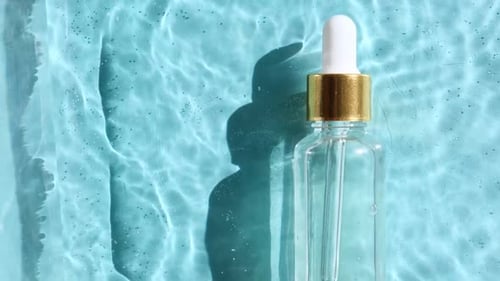 Dropper Bottle on Rippled Blue Background