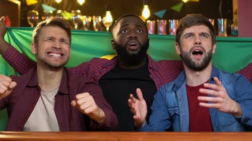 Three Friends Watching Sports in Bar at Night