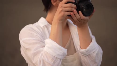 Woman Taking a Picture with a Black Camera