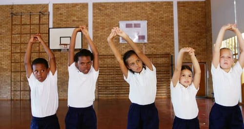 Crianças em idade escolar se exercitando na quadra de basquete
