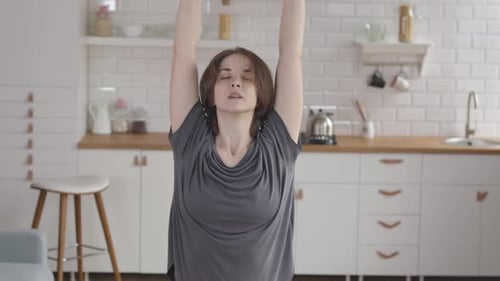 Woman Stretching On Yoga Mat At Home