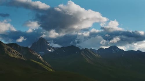 Scenic Mountain Range Under Cloudy Blue Sky