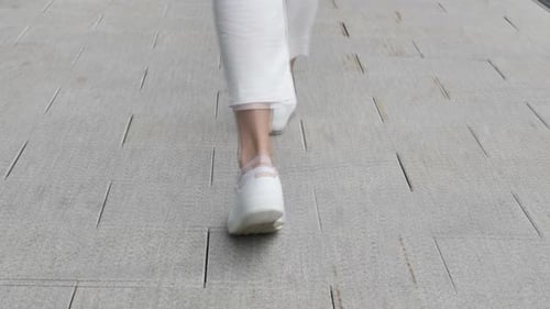 Back View of Walking Female Legs on Street