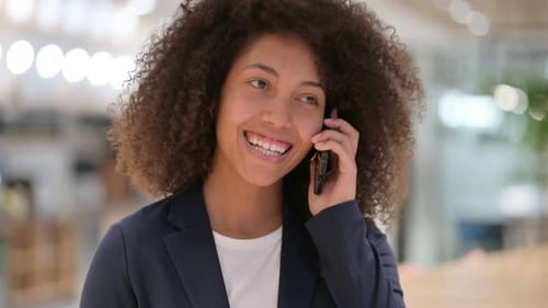 Woman Speaking on Mobile Phone in Office