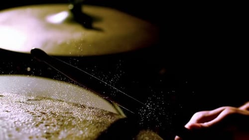 Drummer playing at the drums with drum stick