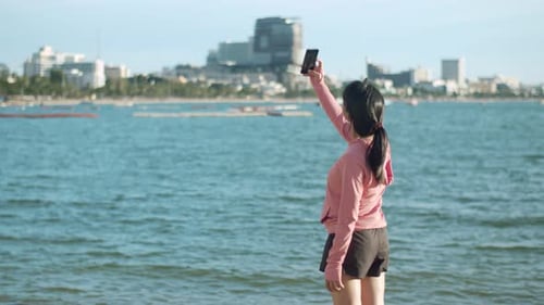 Woman Video Calling on Beachfront With City View
