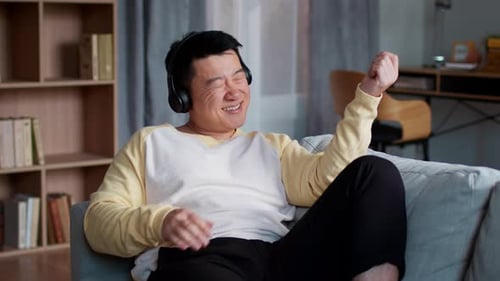Man Enjoying Music on Headphones Playing Air Guitar