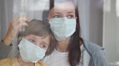 Woman and Child Wearing Face Masks Embrace